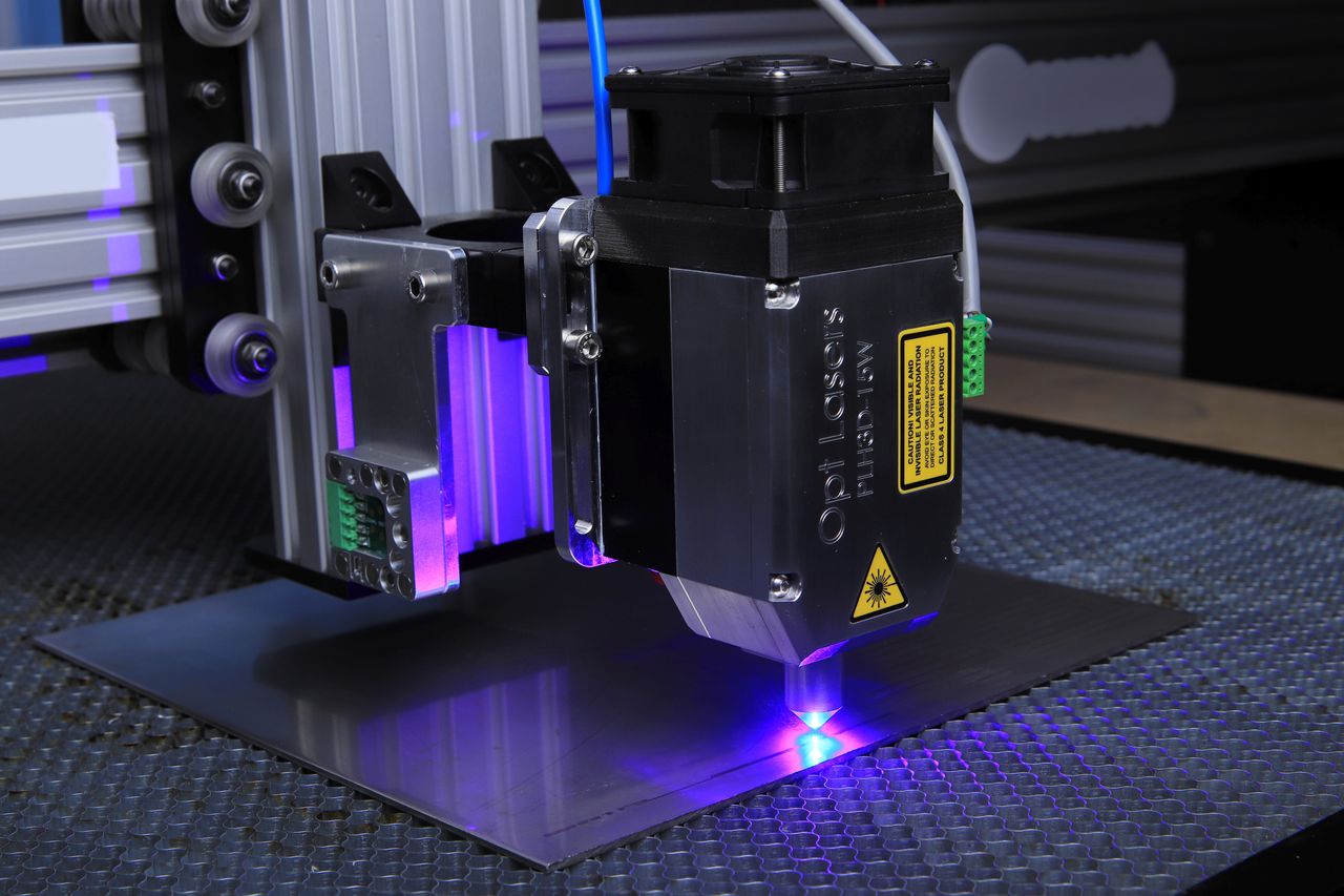 Laser engraving machine operating on metal surface with blue laser light
