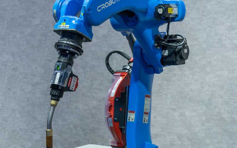 KUKA robot hand welding a metal part on an automated factory production line